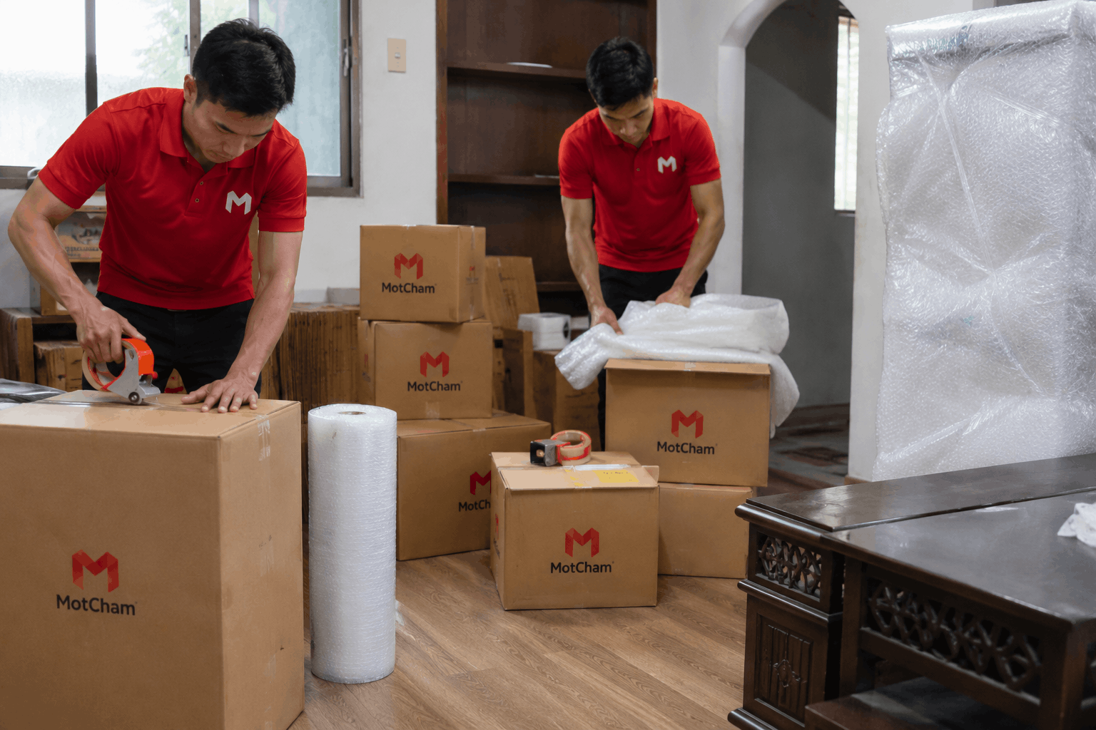 Nhân viên MotCham đóng gói thùng carton cẩn thận trong dịch vụ chuyển nhà trọn gói Bến Tre giúp bảo vệ tài sản an toàn.